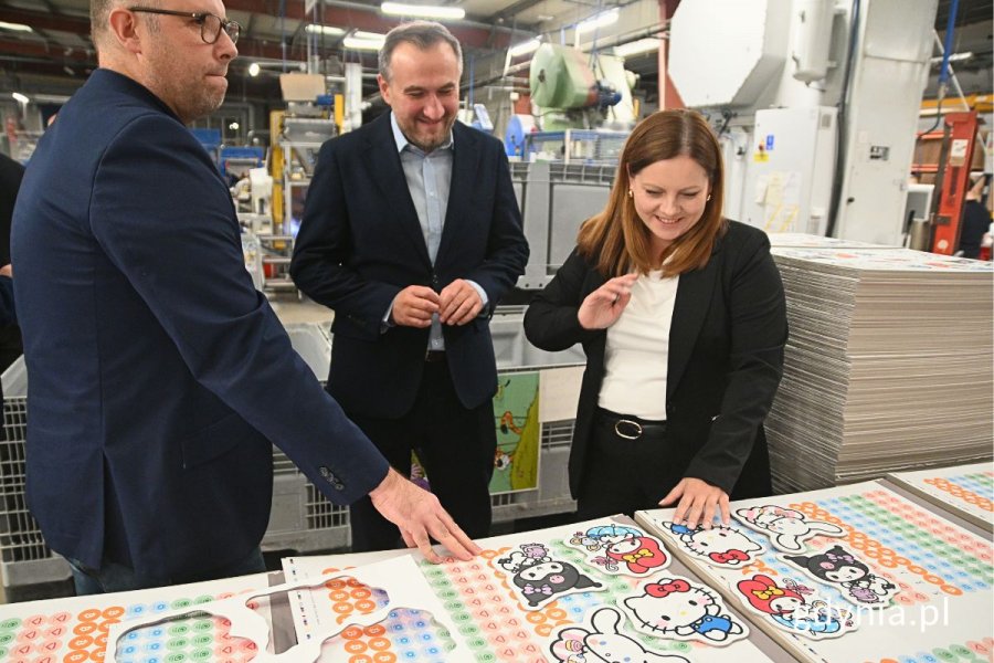 Grupa osób oglądająca maszyny używane do produkcji puzzli i gier