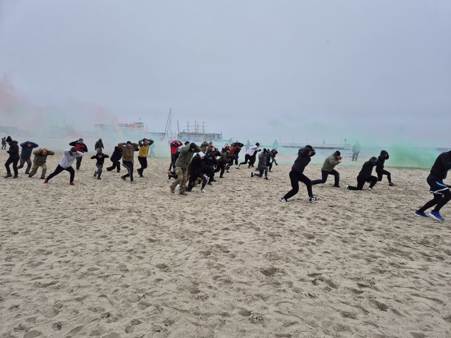 Biegnący uczestnicy treningu z Formozą w ramach kampanii „Odważni wygrywają” na plaży Śródmieście