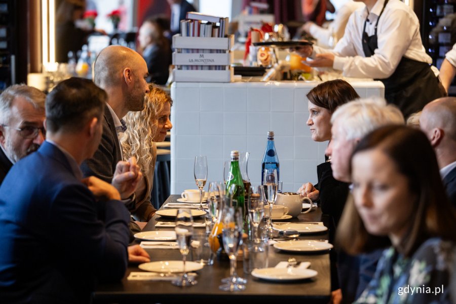 Ludzie rozmawiają przy stole w restauracji.