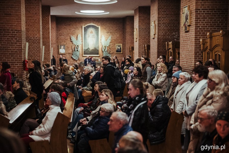 Mieszkańcy siedzący w kościelnych ławach 