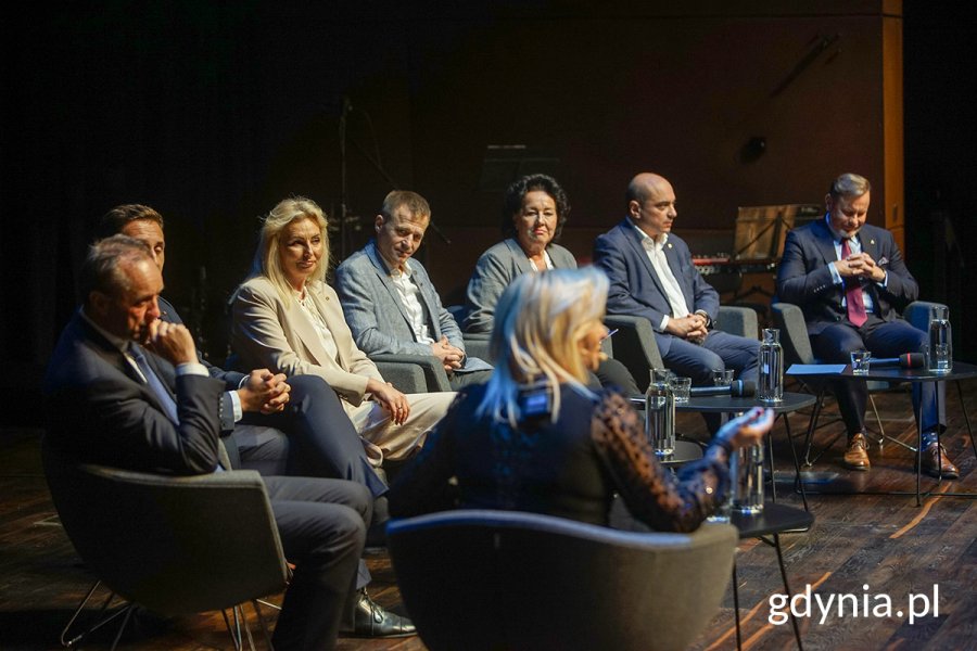 Na zdjęciu ludzie debatujący w półokręgu