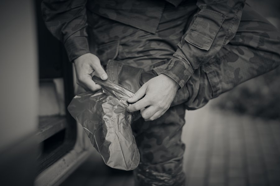 Żołnierz w mundurze zakłada ochronną osłonę na buty // fot. st. chor. szt. mar. Piotr Leoniak