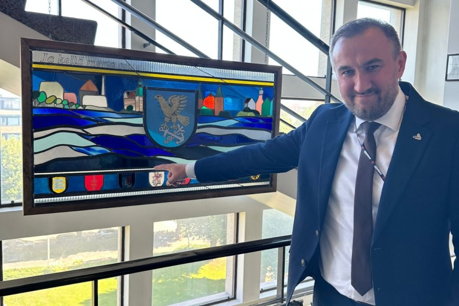 Wiceprezydent Gdyni Tomasz Augustyniak wskazuje na herb naszego miasta, który jest wyeksponowany w głównym holu ratusza w Kotce