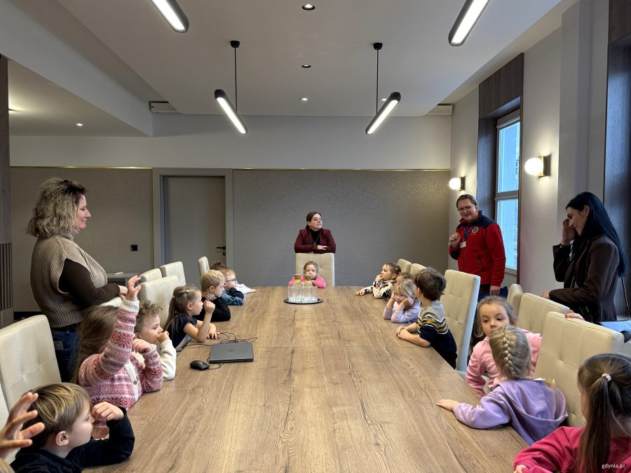 Dzieci za stołem zadają pytania