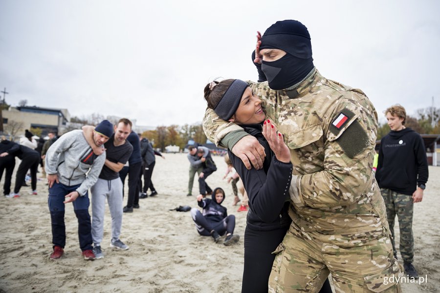 Mieszkańcy ćwiczą na plaży z komandosami.