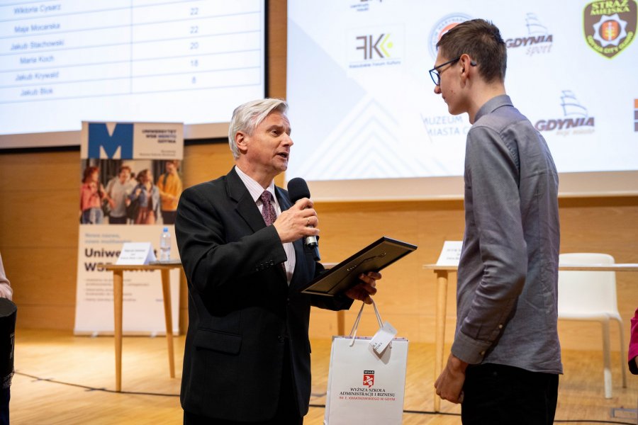 dr Cezary Tatarczuk, Pełnomocnik Rektora ds. Jakości Kształcenia Wyższej Szkoły Administracji i Biznesu im. Eugeniusza Kwiatkowskiego wręcza nagrodę finaliście konkursu/  fot. Uniwersytet WSB Merito Gdynia