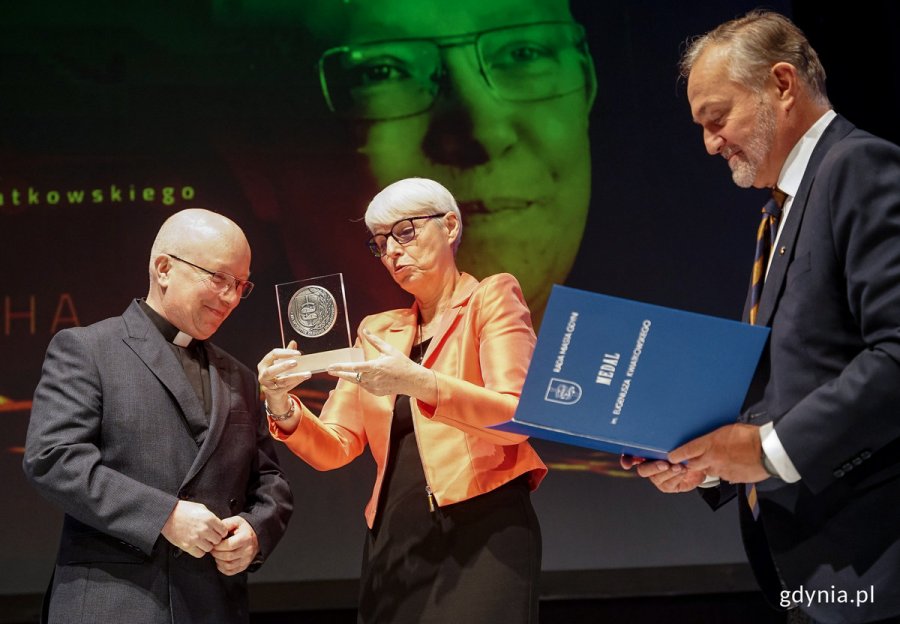 Medal im. Eugeniusza Kwiatkowskiego księdzu Jackowi Sosze wręczają przewodnicząca Rady Miasta Gdyni Joanna Zielińska i Prezydent Wojciech Szczurek / Fot. Mirosław Pieślak