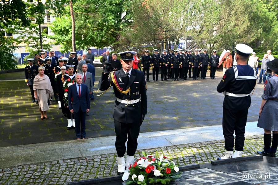 Na pierwszym planie marynarz składający kwiaty od senatora Sławomira Rybickiego przed pomnikiem Obrońców Wybrzeża na Cmentarzu Wojennym w Redłowie. Na końcu schodów stoi senator Sławomir Rybicki, a za nim inne delegacje // fot. Magdalena Czernek