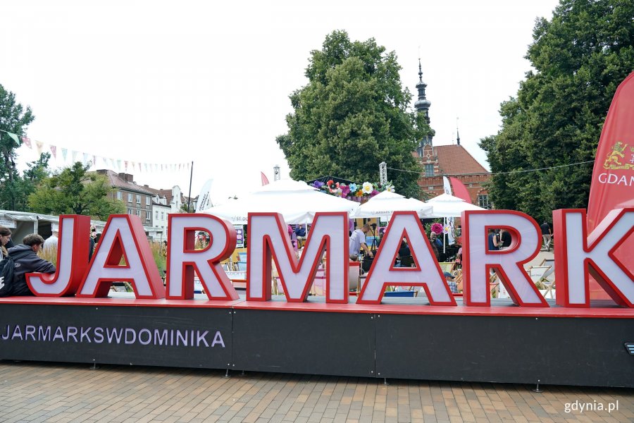 Biało-czerwony napis "Jarmark" przy Przystanku Równość na skwerze Heweliusza w Gdańsku