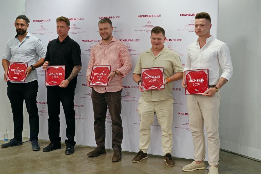 Restauratorzy, kt&oacute;rzy zdobyli rekomendacje przewodnika Michelin 2026 z plakietami. Wśr&oacute;d nich (w środku) Piotr Ciomek z Oberży 86 