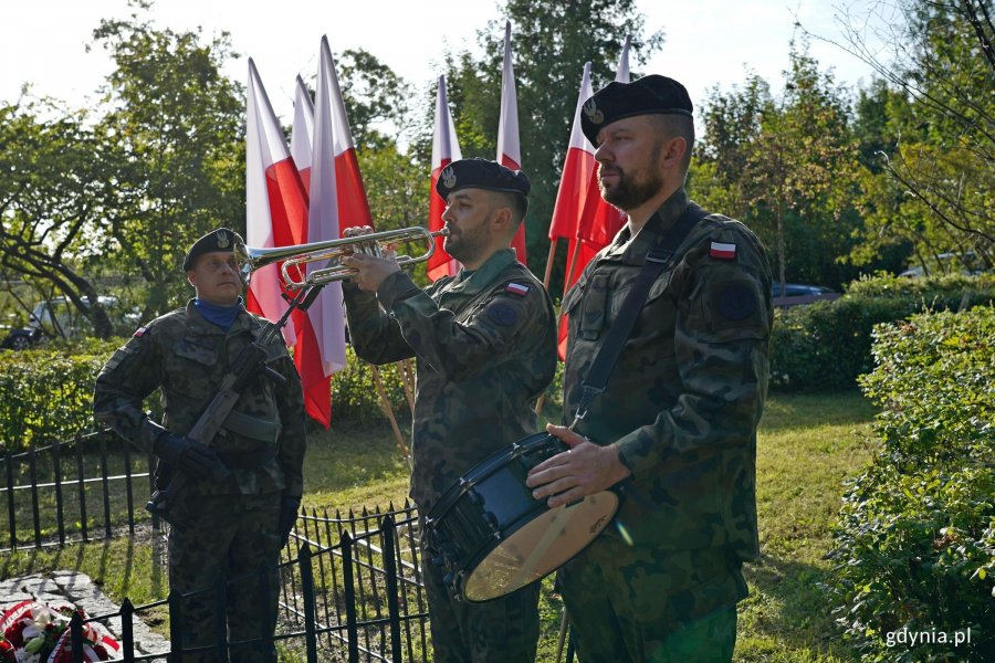 Trębacz i werblista oraz żołnierz stojący na posterunku honorowym przy Obelisku Obrońc&oacute;w Kępy Oksywskiej na Babich Dołach podczas uroczystości z okazji 87. rocznicy zakończenia walk w obronie Kępy Oksywskiej