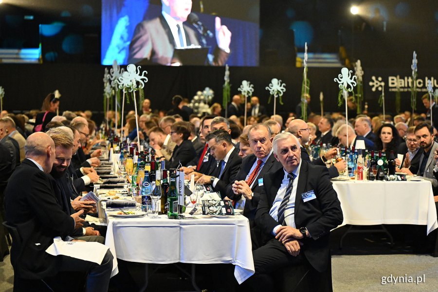 Goście siedzą przy zastawionych stołach