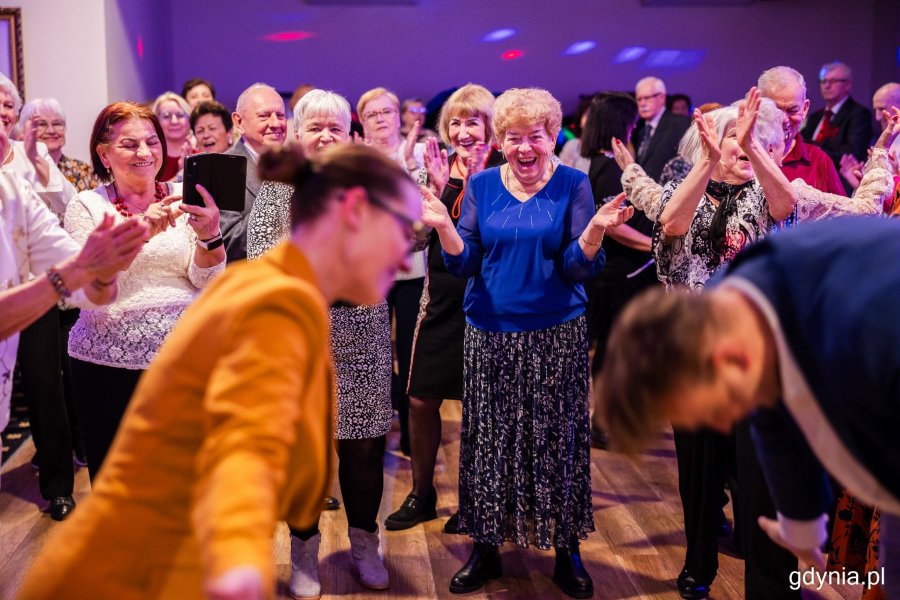 Grupa os&oacute;b tańczy na parkiecie