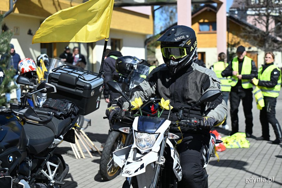 Monocyklista w kasku z żonkilem