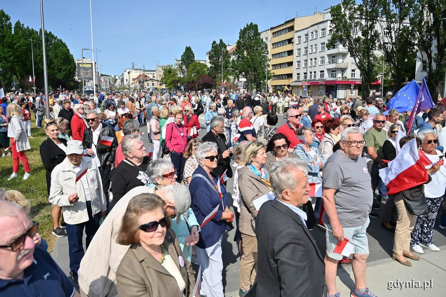 Mieszkańcy z biało-czerwonymi chorągiewkami na skwerze Kościuszki