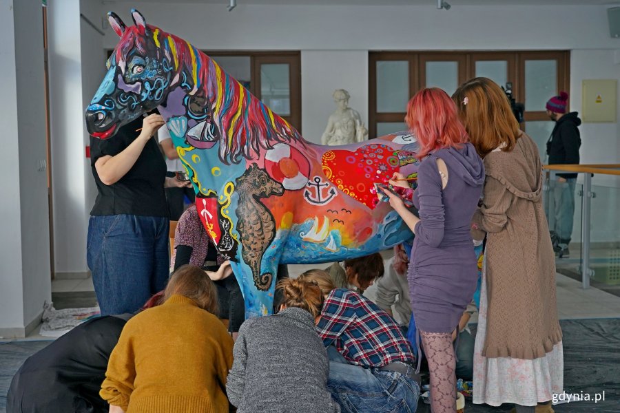 Uczniowie Państwowego Liceum Sztuk Plastycznych w Gdyni malujący rzeźbę konia, kt&oacute;rego miasto przekaże na licytację WOŚP 