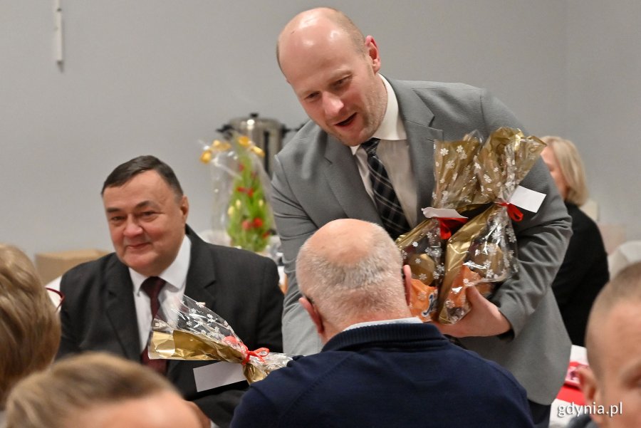 Wigilia dla seniorów w Przystani Chylońska 237, na zdjęciu wiceprezydent Bartoszewicz wręcza seniorom drobne upominki