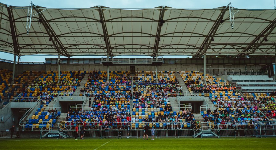 Dzieci siedzące na trybunach Stadionu Miejskiego 