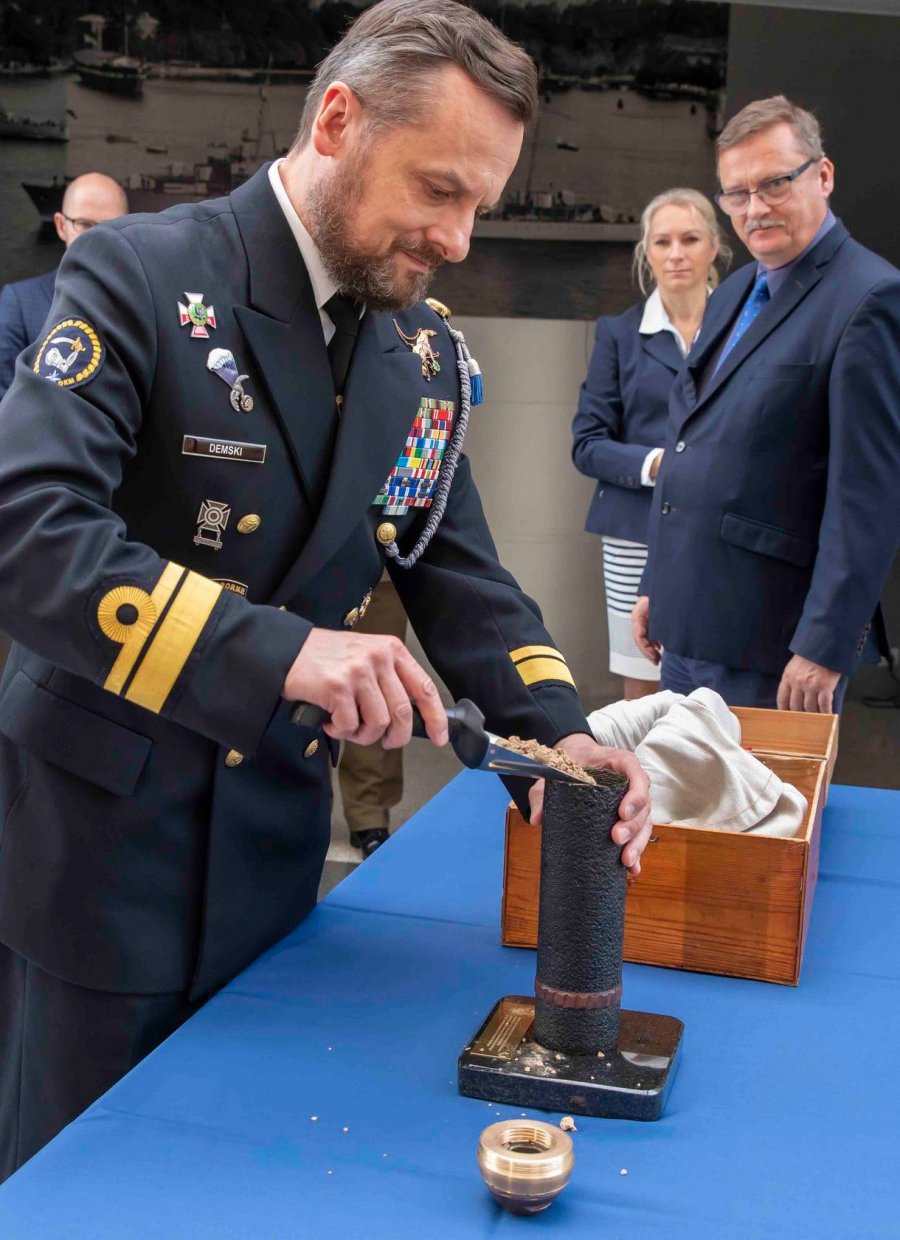  Kmdr ppor. Dariusz Demski ze Stowarzyszenia Kombatantów Misji Pokojowych ONZ przesypuje ziemię do szklanki od szrapnela, czyli pocisku artyleryjskiego // fot. H. Nagrodzki/ MMW  