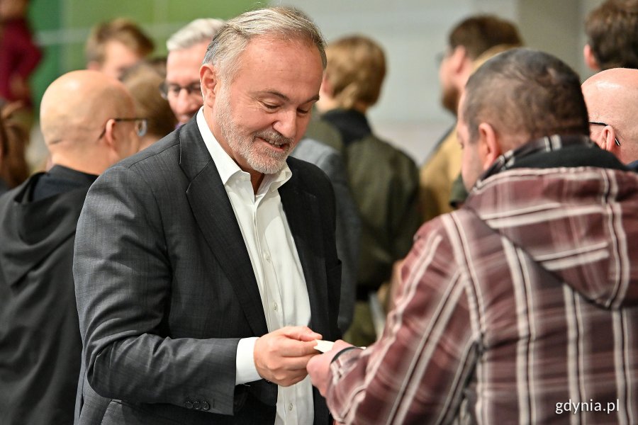 Prezydent Gdyni Wojciech Szczurek łamie się opłatkiem z uczestnikiem miejskiej wigilii. Fot. Michał Puszczewicz