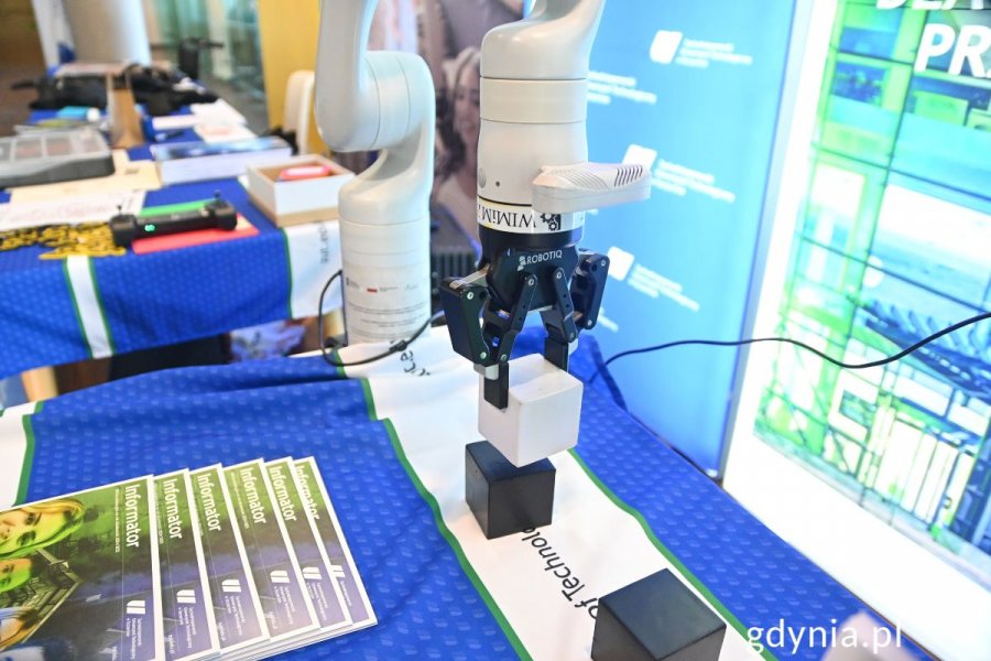 Białe robotyczne ramię na stole na niebieskim obrusie