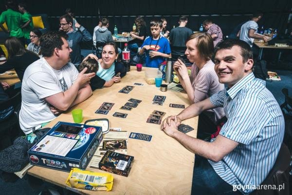 // fot. Dawid Linkowski, gdyniaarena.pl. Uczestnicy wydarzenia przy stole z grami planszowymi