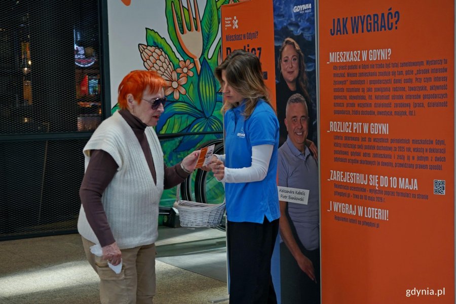 Konsultantka rozmawiająca z mieszkanką przy stoisku informacyjnym loterii &bdquo;Rozlicz PIT w Gdyni&rdquo; w Centrum Handlowym Batory 