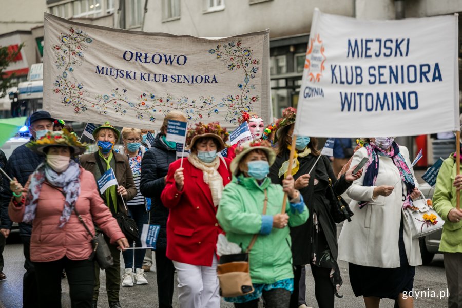 Wielobarwny Pomorski Przemarsz Seniorów ulicami Gdyni. Seniorki niosą transparenty. Fot. Karol Stańczak
