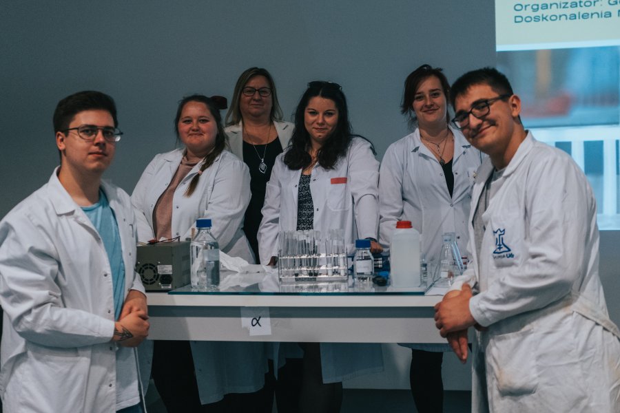 Studenci w białych fartuchach z odczynnikami