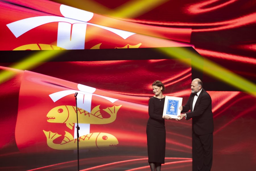 Na scenie, na tle godła Gdyni stoją (od lewej): wiceprezydentka Gdyni Katarzyna Gruszecka-Spychała i aktor Bernard Szyc
