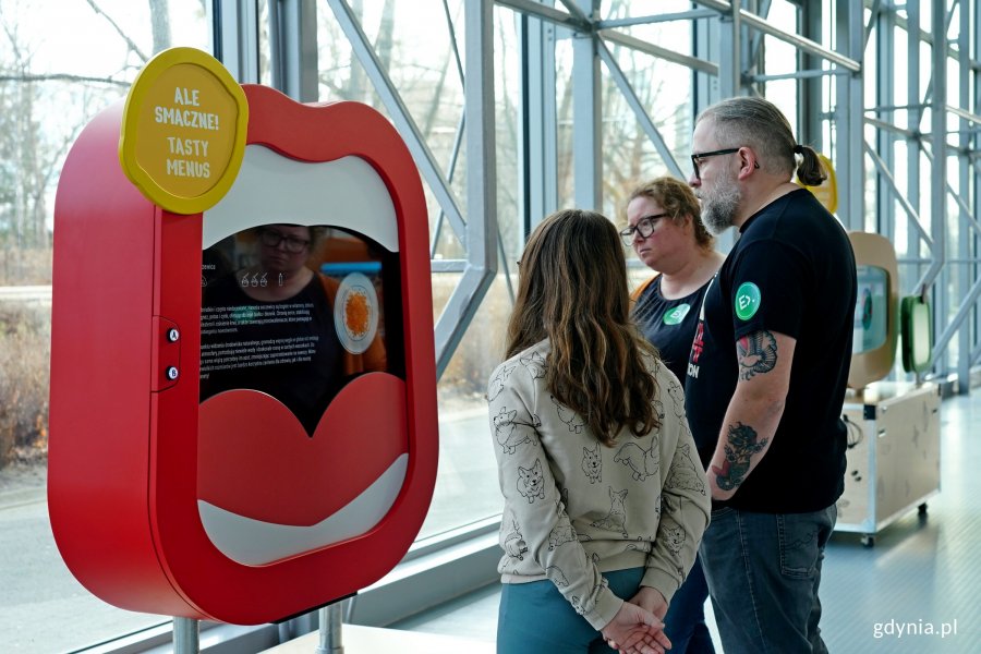 Kobieta i mężczyzna oraz dziecko podczas oglądania wystawy „CLEVERFOOD for everyone” 