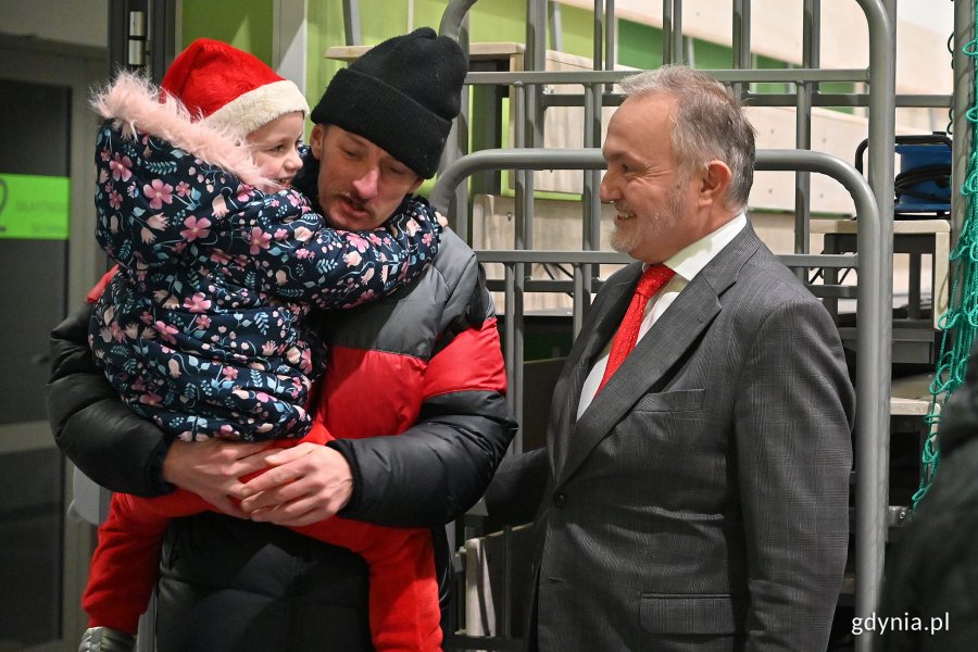 Prezydent Wojciech Szczurek wita gości wieczerzy: mężczyznę z dzieckiem