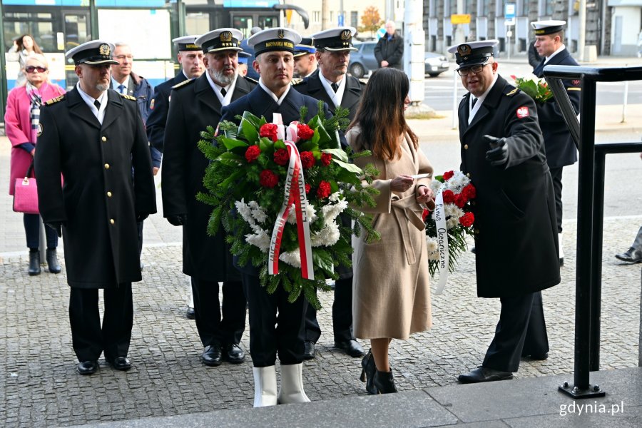 Uczestnicy uroczystości złozyli wieńce i wiązanki kwiatów pod tablicą pamiątkową na fasadzie Dworca PKP Gdynia Główna // fot. Magdalena Czernek