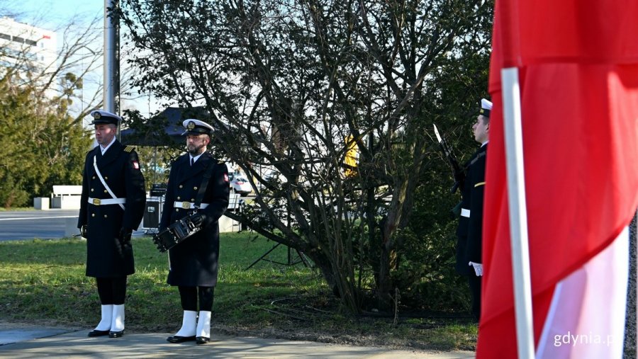 Po lewej: werblista i trębacz z Orkiestry Reprezentacyjnej Marynarki Wojennej, a po prawej - biało-czerwona flaga oraz jeden z żołnierzy z posterunku honorowego przy pomniku AK na skwerze Kościuszki podczas obchodów 81. rocznicy utworzenia Armii Krajowej // fot. Magdalena Czernek