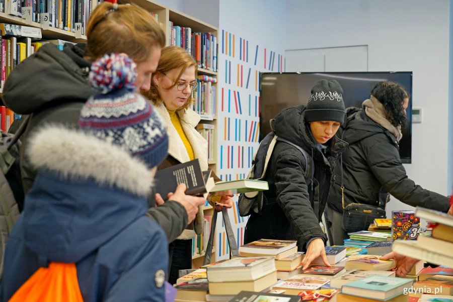 Uczestnicy charytatywnego kiermaszu w Bibliotece Śr&oacute;dmieście podczas przeglądania książek 