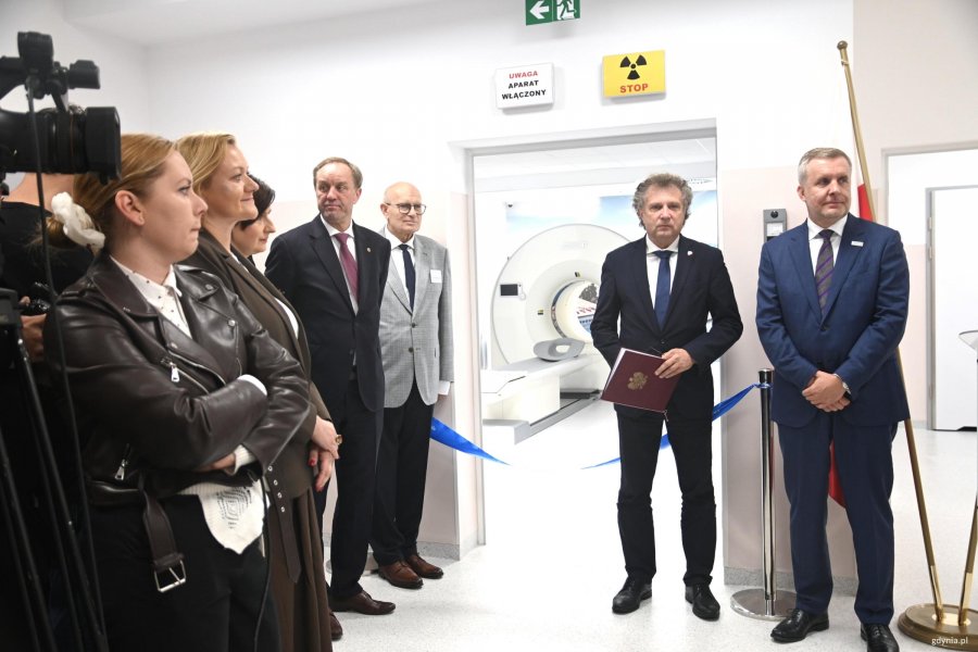 Grupa os&oacute;b przy niebieskiej wstędze