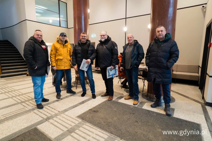 Cieoło ubrani ludzie w holu magistratu