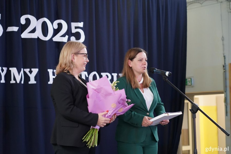Od prawej: prezydent Aleksandra Kosiorek i wiceprezydentka Oktawia Gorzeńska na scenie z kwiatami i upominkami dla dyrektor szkoły