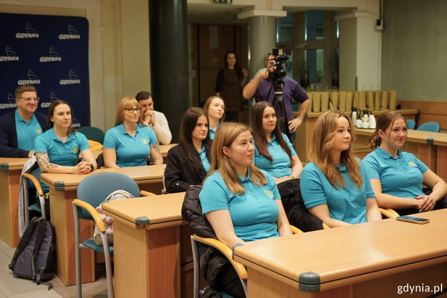 Zawodniczki Rugby Arka Gdynia siedzą w sali obrad Urzędu Miasta Gdyni