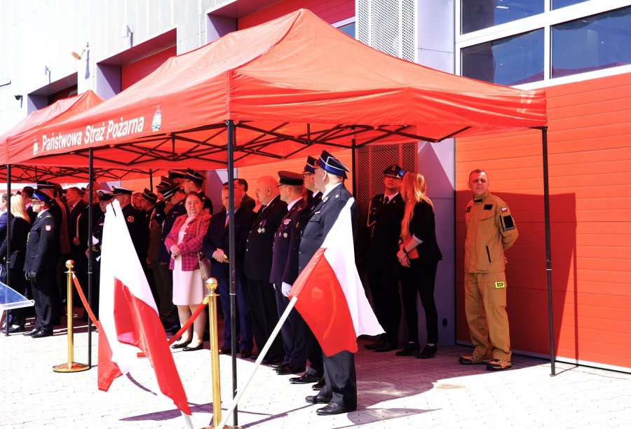 Goście w mundurach po cywilnemu pod czerwonym namiotem