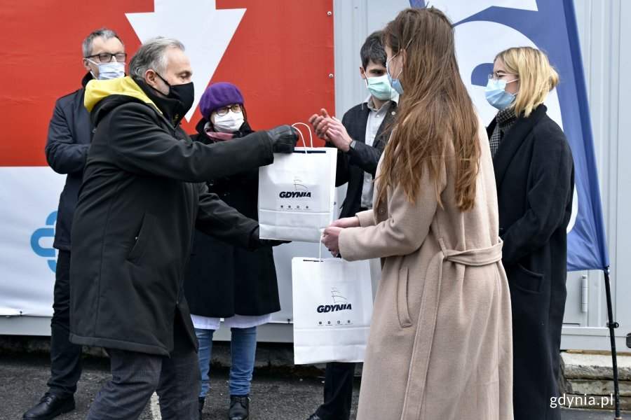 Prezydent Gdyni Wojciech Szczurek wręcza dyplom i drobne upominki studentom Gdańskiego Centrum Medycznego, którzy pracują w centrum testowym COVID-19 drive-thru przy IMMiT // fot. Magdalena Czernek