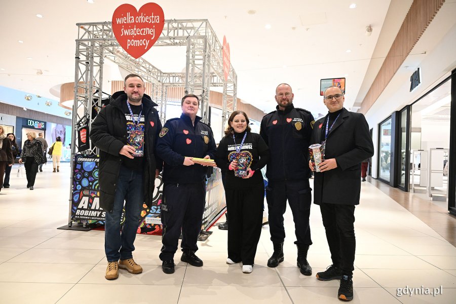 Wicewojewoda pomorski Emil Rojek, prezydent Gdyni Aleksandra Kosiorek i wiceprezydent Tomasz Augustyniak ze strażnikami miejskimi podczas finału WOŚP w Centrum Riviera 