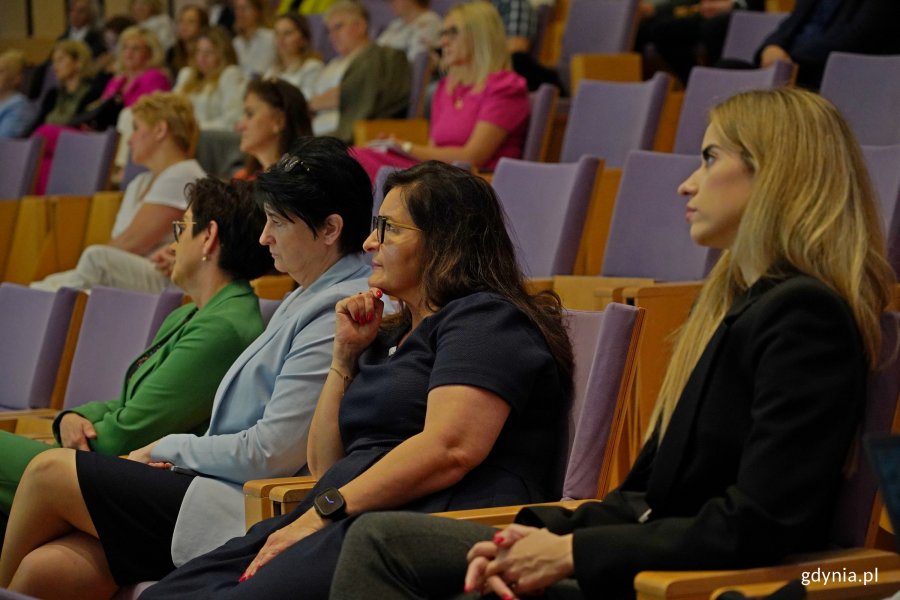 Kobiety siedzące na widnowni obserwują wystąpienie na scenie