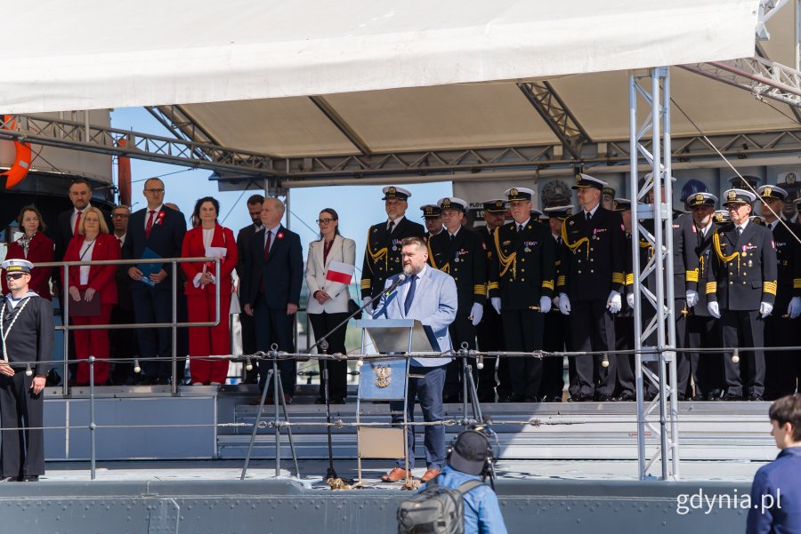 Na zdjęciu: przy mikrofonie Tadeusz Szemiot, przewodniczący RMG, a obok m.in.: senator Sławomir Rybicki, posłanki Wioleta Tomczak i Dorota Arciszewska-Mielewczyk, wicewojewoda pomorski Emil Rojek, członkini zarządu wojew&oacute;dztwa pomorskiego Agnieszka Baranowska, wiceprezydent Gdyni Tomasz Augustyniak, radni miasta &ndash; Teresa Bysewska, Larysa Kramin, Agnieszka Tokarska i  Norbert Anisowicz oraz przedstawiciele Marynarki Wojennej 