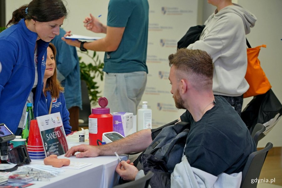 Jeden z uczestnik&oacute;w akcji z okazji Dnia Mężczyzny przy stoisku medycznym na pasażu Centrum Handlowego Riviera 