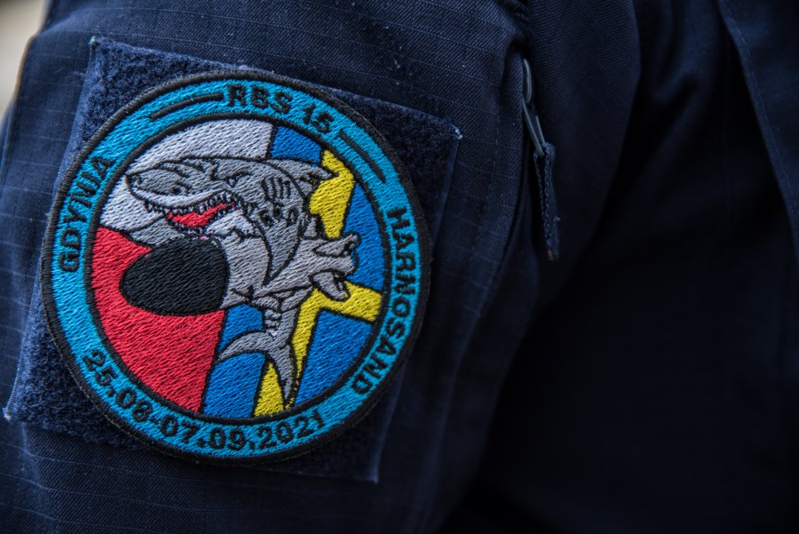 Naszywka z logiem ćwiczeń umieszczona na mundurze jednego z marynarzy. W okrągłym kółku widać rekina, który trzyma pocisk rakietowy. W tle umieszczono flagi Polski i Szwecji // fot. bsmt Michał Pietrzak