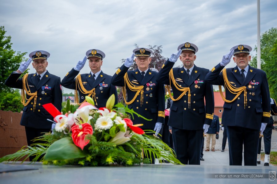 Marynarze skłądają kwiaty na cmentarzu.