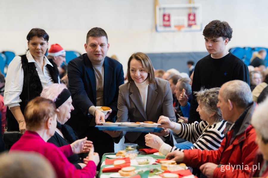 Wiceprezydent Maciej Zielonka i radna miasta Larysa Kramin roznoszący świąteczne potrawy gościom wigilii dla samotnych i potrzebujących