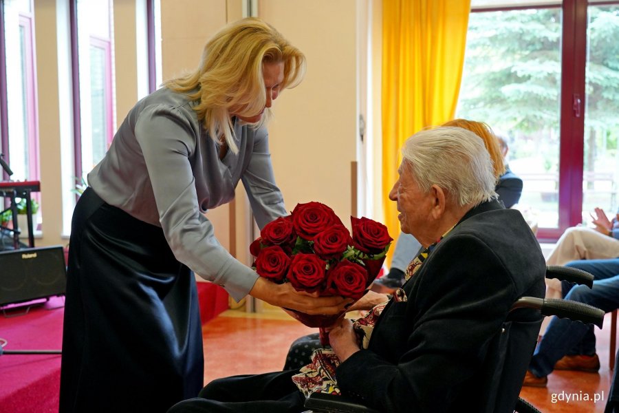 Lilianna Szewczuk-Putrym, dyrektor Domu Pomocy Społecznej w Gdyni, wręczająca kwiaty Przemysławowi Dyakowskiemu