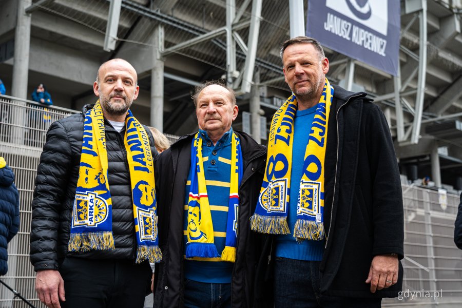 Arkadiusz i Sebastian Kupcewiczowie (z lewej i z prawej) pozują do zdjęcia. Symboliczne odsłonięcie tablicy z nazwą placu Janusza Kupcewicza przy Stadionie Miejskim w Gdyni (fot. Kamil Złoch)